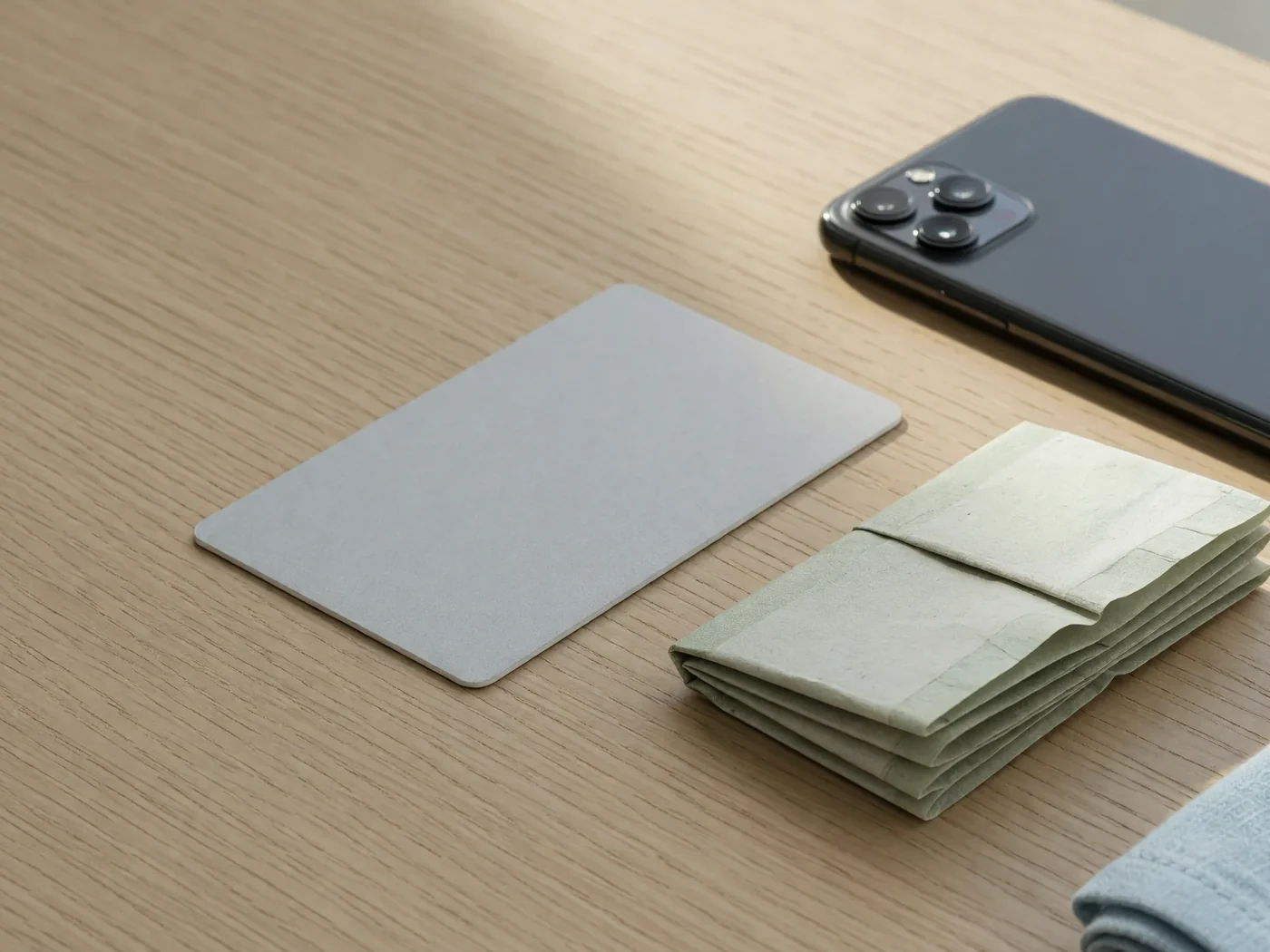 Blank-faced card, folded currency with hidden numerals, phone screen-down