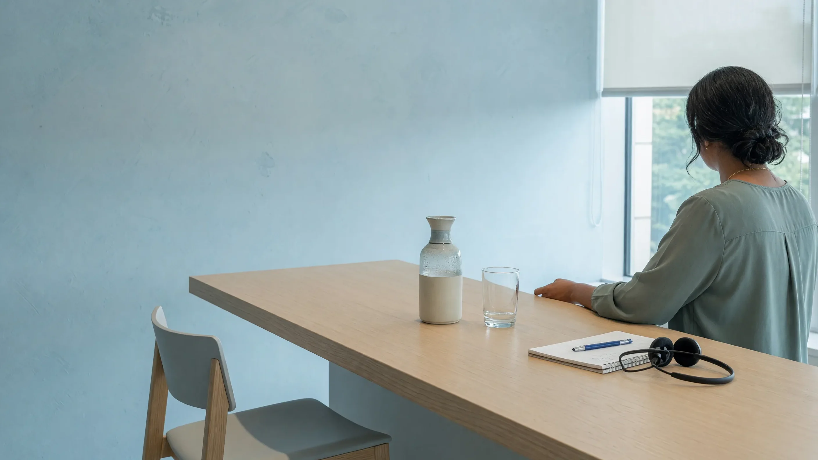 Empty visitor chair, notepad and headset at a bright counter